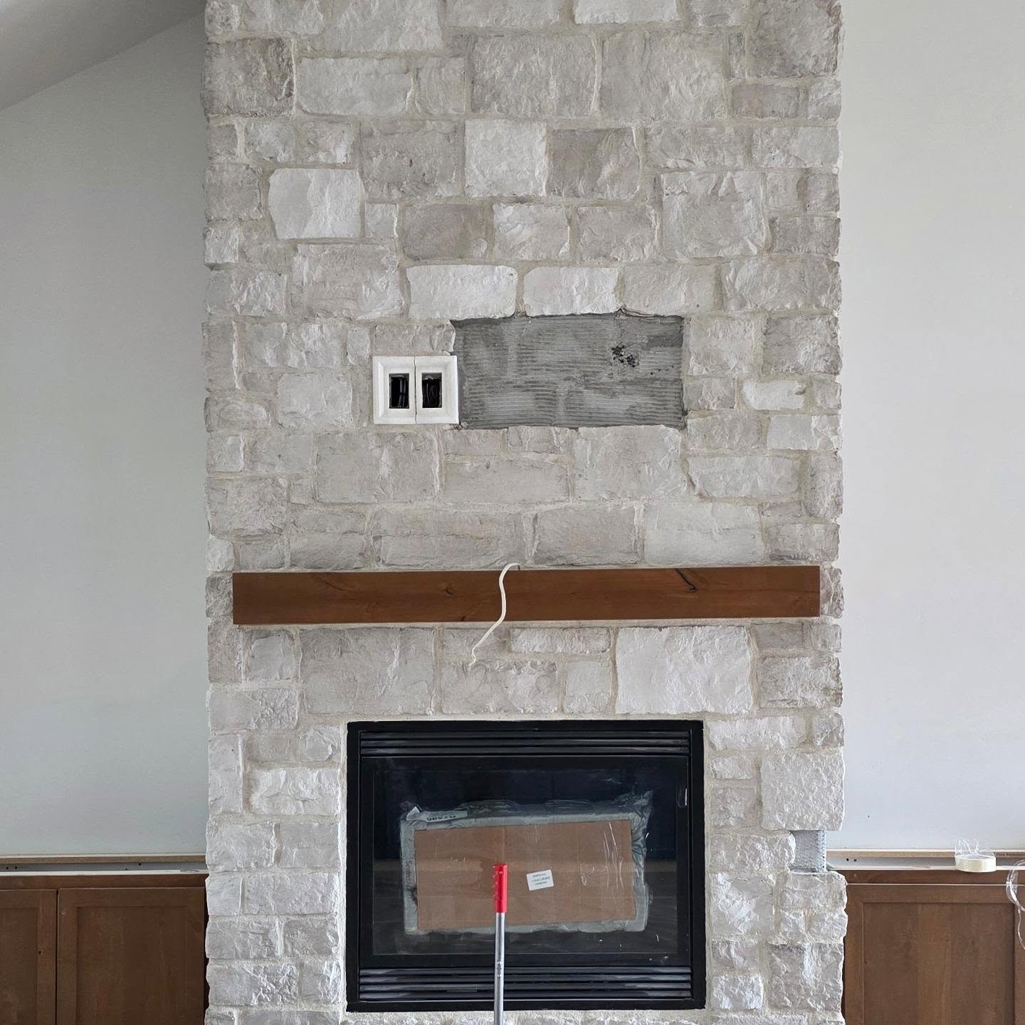 Stone fireplace with wood mantel
