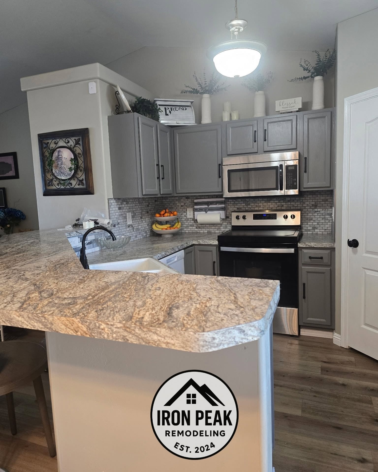 Kitchen with gray cabinets, stone countertops and an Iron Peak branded island