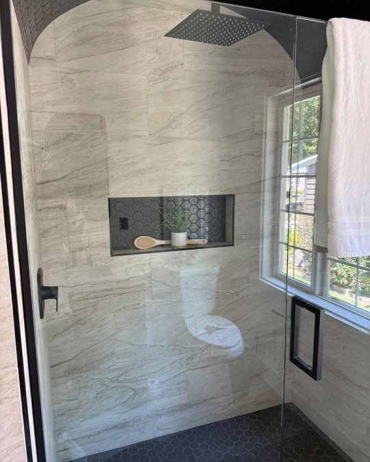 Marble-tile walk-in shower with hex tile floor