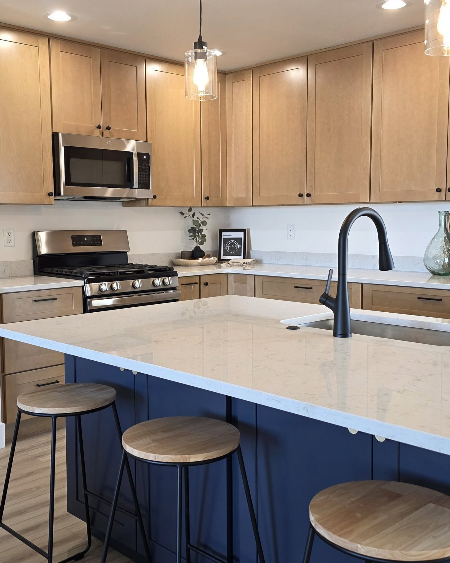 Bright white kitchen with a large island, bar stools and pendant lights